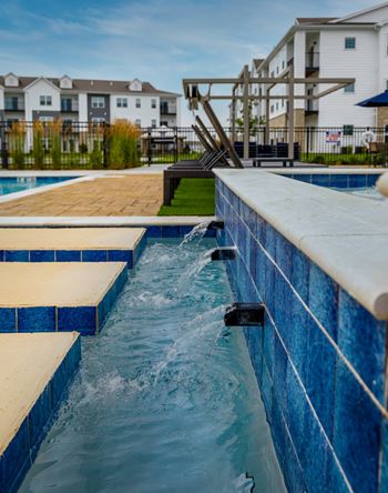 A blue tiled pool with a waterfall feature.